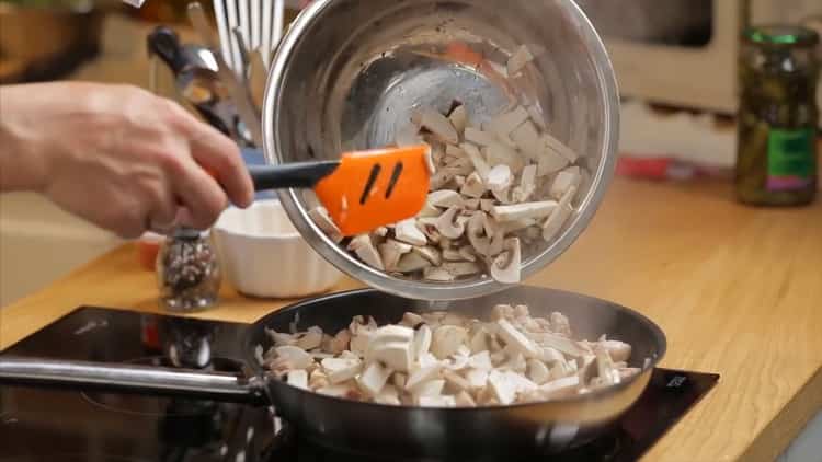 Per fare una torta con pollo e funghi, aggiungi i funghi nella padella