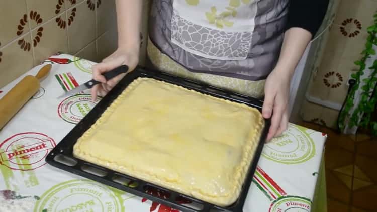 Per fare una torta con pesce e patate, ungere l'impasto con un uovo