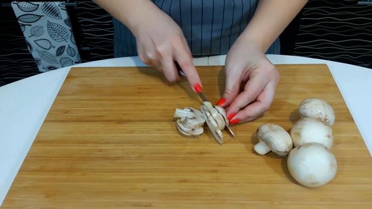 Per preparare la pizza a casa, tagliare i funghi.