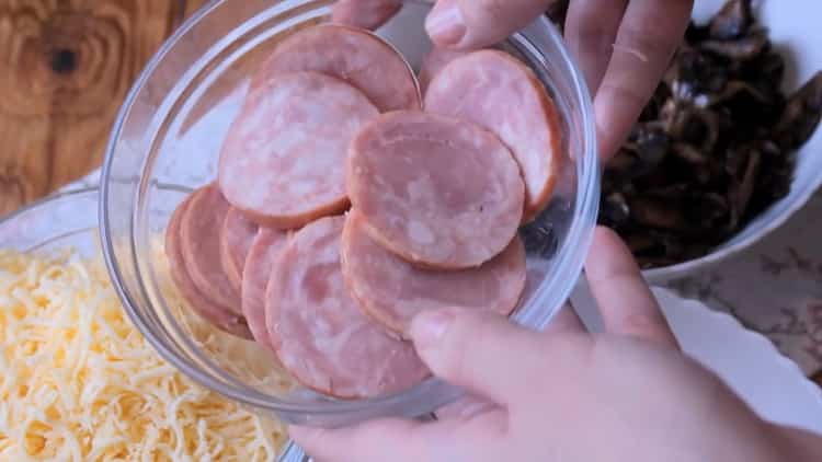 Per cuocere la pizza nel forno, tagliare la salsiccia