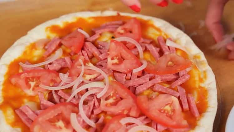 Per cuocere la pizza nel microonde, metti tutti gli ingredienti sulla torta