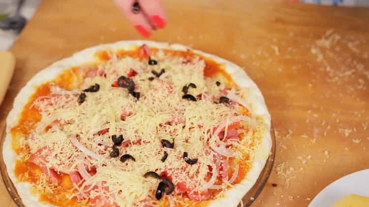 Per fare la pizza nel microonde, metti il ​​formaggio grattugiato sulla torta