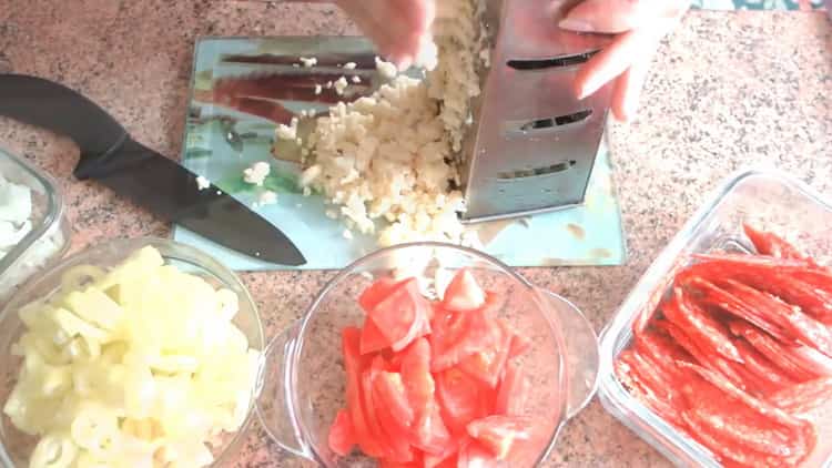 Per fare la pasta sfoglia al forno, grattugiare il formaggio