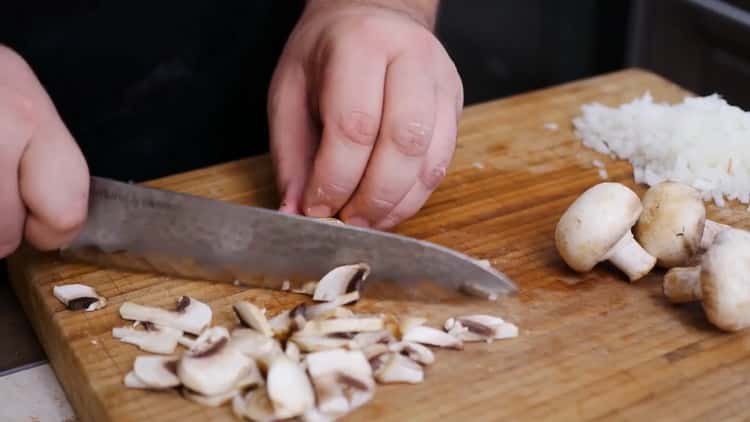 Per preparare una torta per pizza, tagliare i funghi