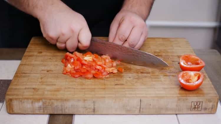 Per fare una torta per pizza, tagliare i pomodori