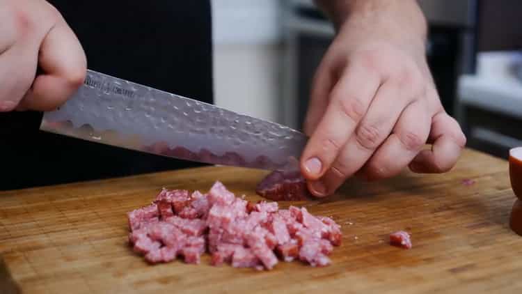 Per fare una torta per pizza, tagliare la salsiccia