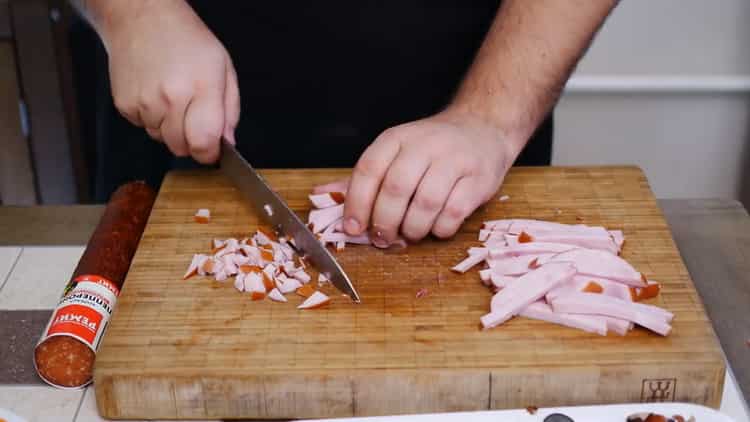 Per preparare una torta per pizza, tagliare il prosciutto