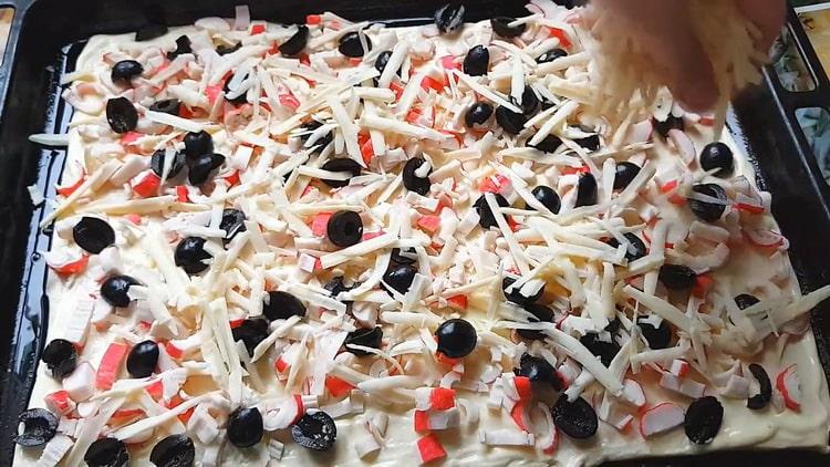 Per fare la pizza con bastoncini di granchio, metti il ​​ripieno sull'impasto