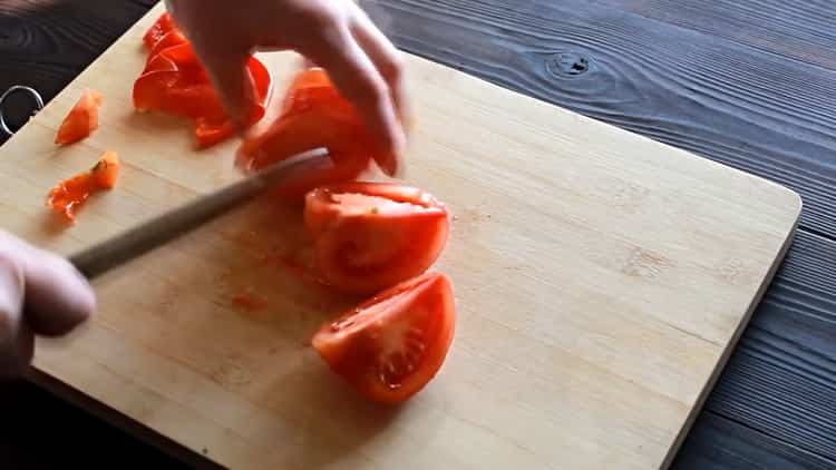 Per fare la pizza con il pollo, tagliare il pomodoro