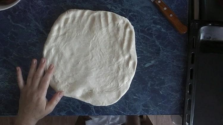 Stendi la pasta per fare la pizza con i sottaceti