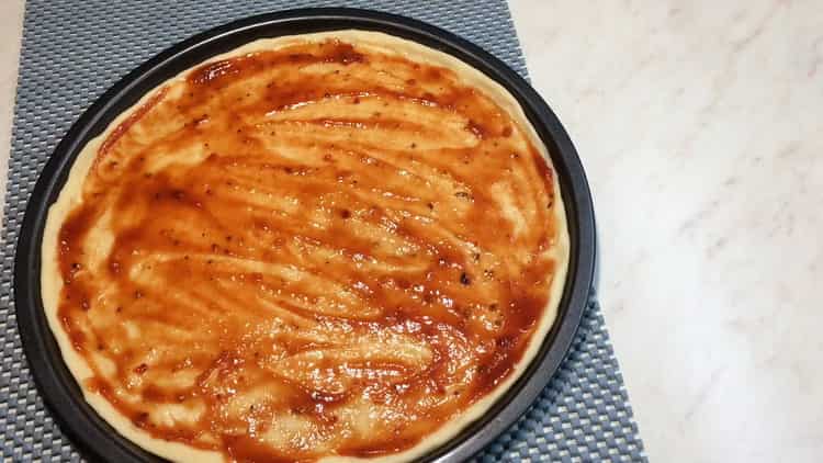 Per la pizza Cesare, ungere l'impasto con la salsa