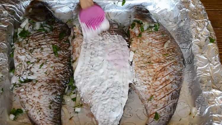 Upang magluto ng isda sa kulay-gatas sa oven, isawsaw ang isda na may kulay-gatas