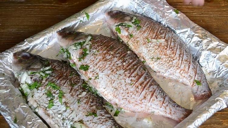 Upang magluto ng isda sa kulay-gatas sa oven, ilagay ang mga sangkap sa isang baking sheet