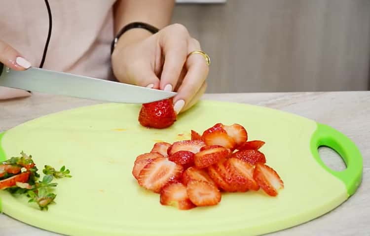 Upang makagawa ng matamis na pizza, i-chop ang mga strawberry