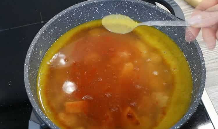 Aggiungi le spezie per preparare la zuppa di lenticchie e pollo