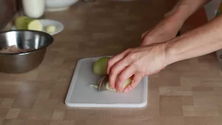 Tritare la cipolla per preparare le fettuccine di pollo.