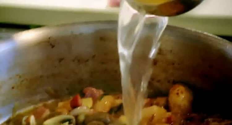 Aggiungi il brodo per preparare la fricassea di coniglio