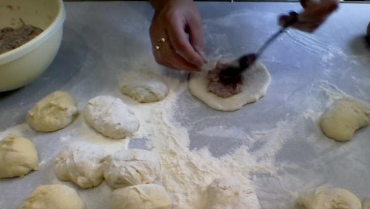 Stendiamo ogni pezzo di pasta, distribuiamo la carne di forza al centro della torta.