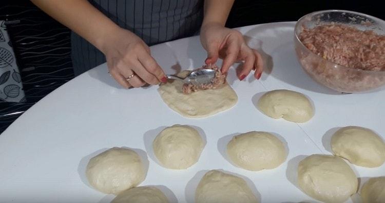 Con le mani livelliamo le palline di pasta in torte, al centro delle quali posizioniamo il ripieno.