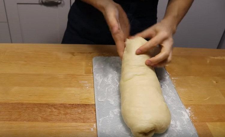 Sotto forma di un tale rotolo, stendi l'impasto su un piatto cosparso di farina.