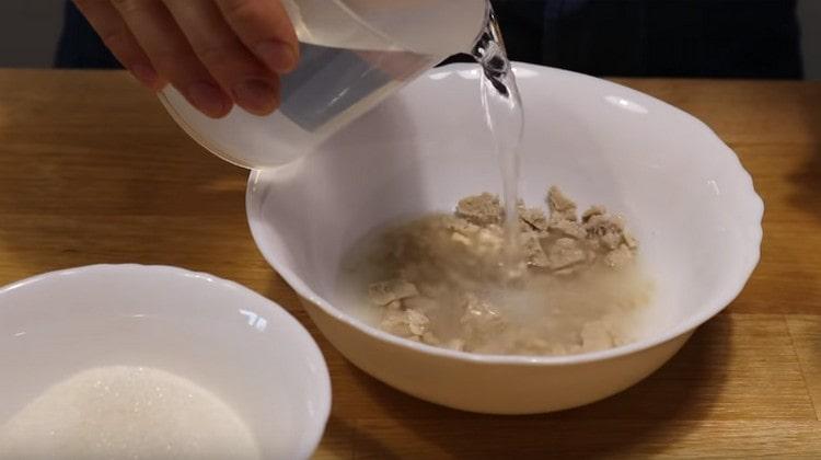 Versare il lievito con acqua calda, aggiungere lo zucchero.