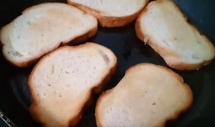 Friggere alcune fette di baguette in una padella con burro.