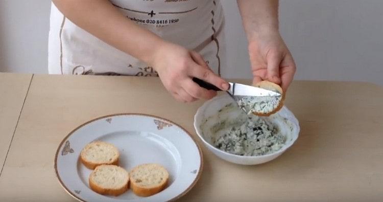 Con una miscela di formaggio ed erbe, diffondiamo fette di baguette.