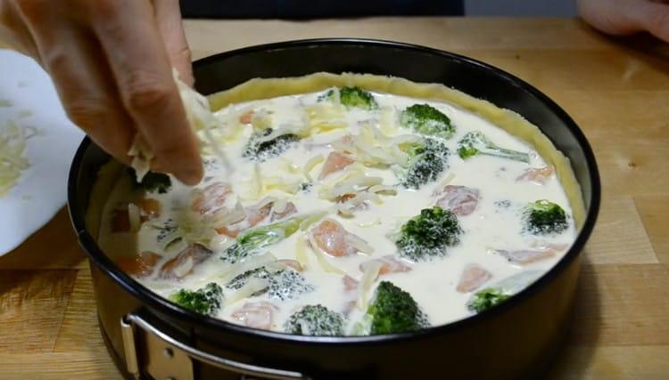 Riempi la torta con ripieno di panna acida, cospargi di formaggio.