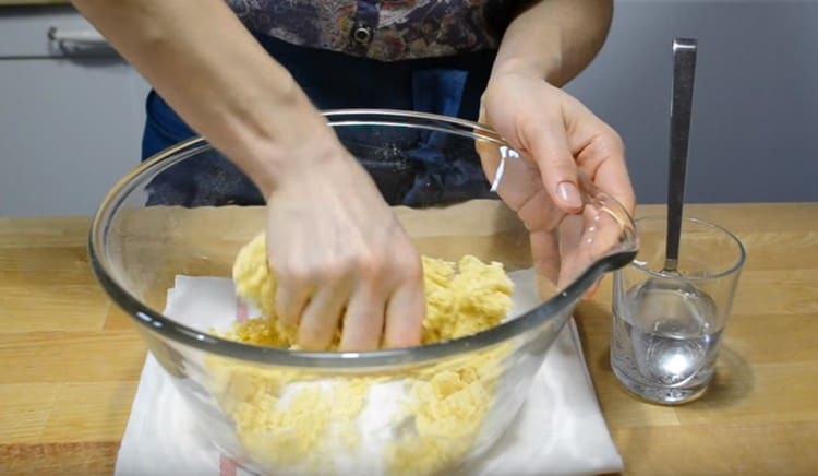 Aggiungi acqua in parti, impasta l'impasto.