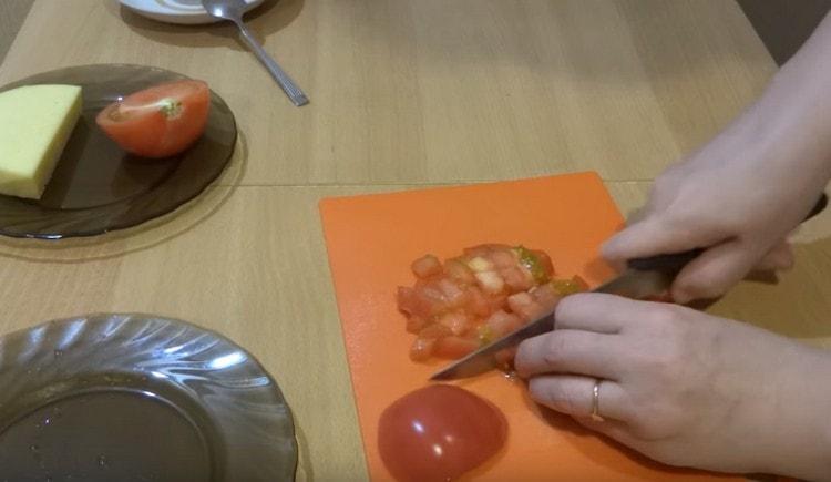 Taglia un pomodoro fresco a dadini.