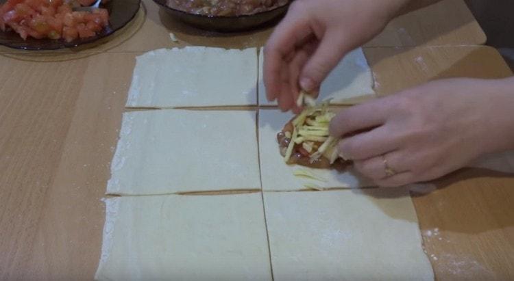 Distribuiamo il ripieno di carne al centro della piazza, aggiungiamo pomodoro e formaggio in cima.