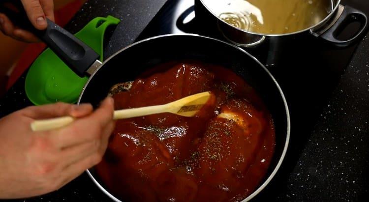 Aggiungi la passata di pomodoro e le erbe di Provenza ai petti di pollo nella padella.