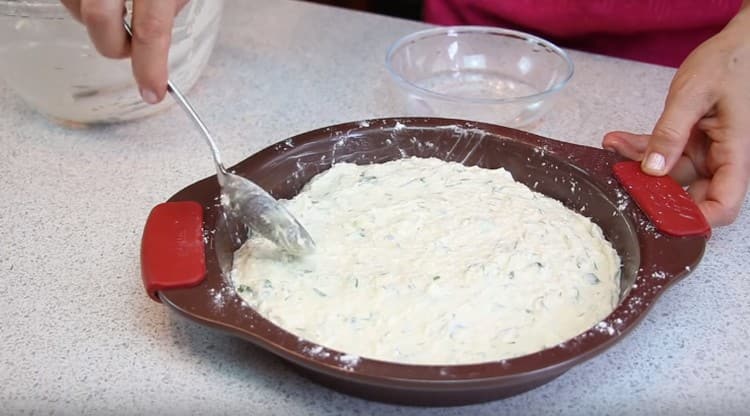 Per cuocere i Khachapuri pigri in forno, metti l'impasto in una forma unta e cosparsa di farina.