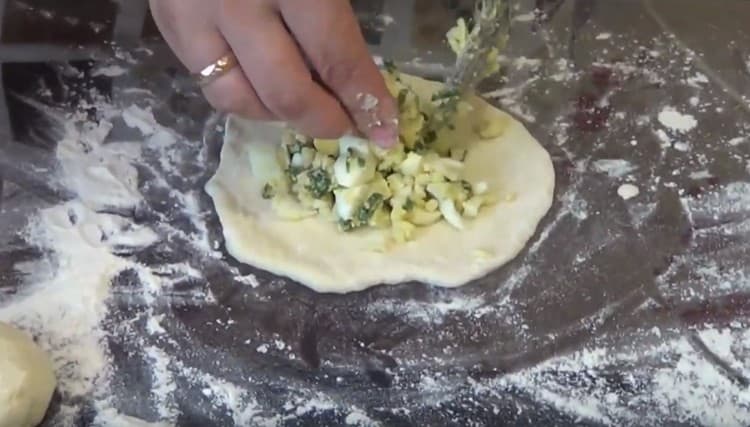 Impastare le palline in torte, al centro delle quali distribuiamo il ripieno.