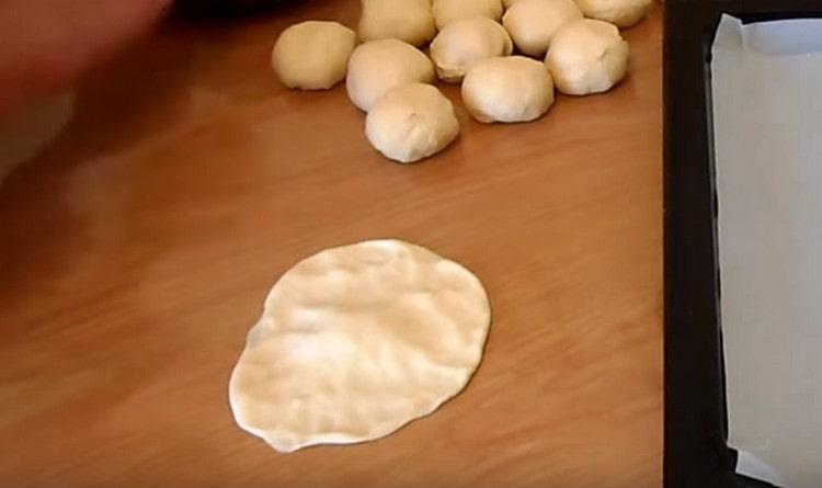 Rotoliamo ogni pallina di pasta in una piccola torta.