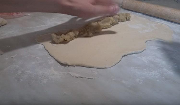 Lungo l'impasto su un lato, stendi il ripieno di patate.