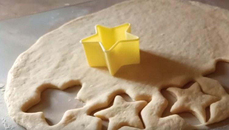 Usando le formine per biscotti, spremere gli spazi vuoti dall'impasto per le focaccine.