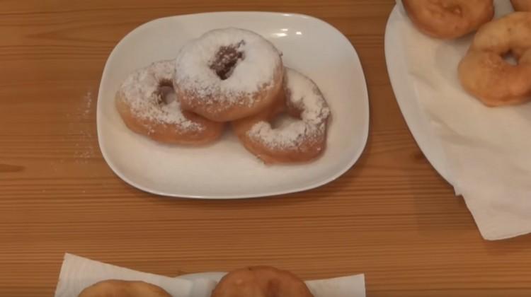 Le ciambelle cotte in padella possono essere cosparse di zucchero a velo per dolcezza.