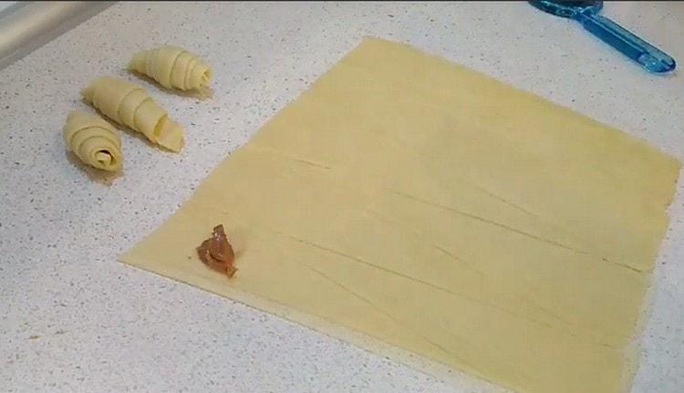 Sul lato largo del triangolo di pasta spalmiamo il ripieno di latte condensato bollito.