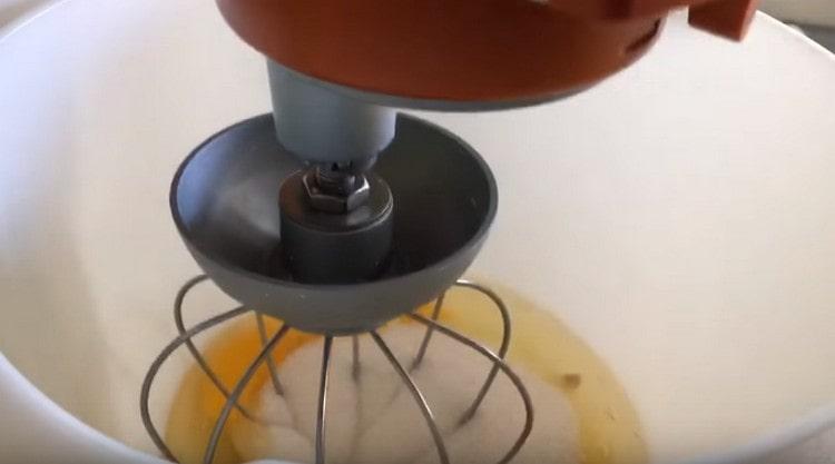 Aggiungi lo zucchero alle uova e sbatti con un mixer.