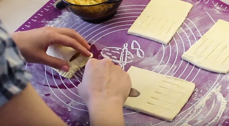 Fissiamo i bordi del bignè, coprendo il ripieno di pasta con fessure.