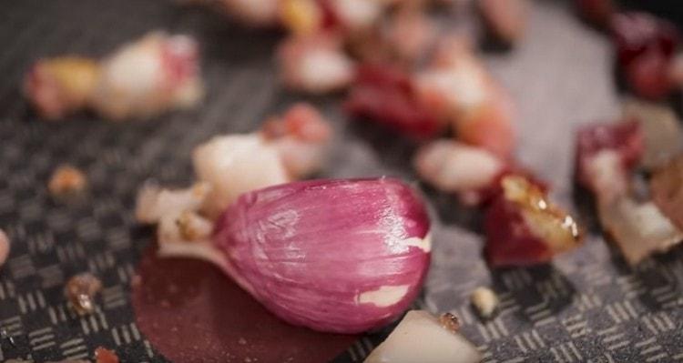 Aggiungi lo spicchio d'aglio schiacciato alla pancetta.