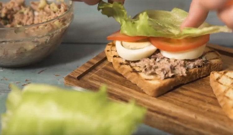 In cima al tonno spalmiamo le fette di uovo, le fette di pomodoro e una foglia di lattuga.