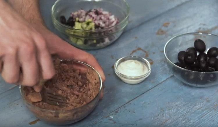 Impastare con una forchetta di tonno in scatola.