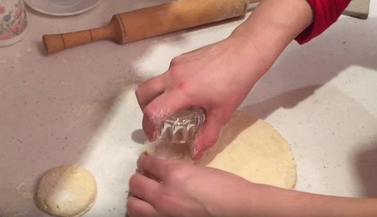 Tagliare i pezzi di pasta rotondi con un bicchiere.