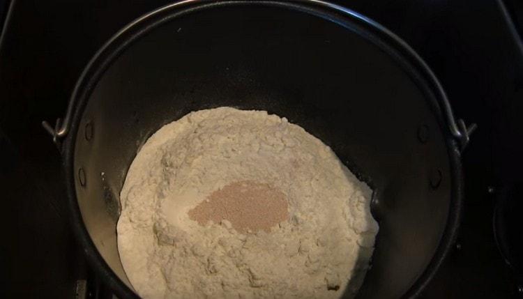 Un secchio pieno di ingredienti, inserito in una macchina per il pane.