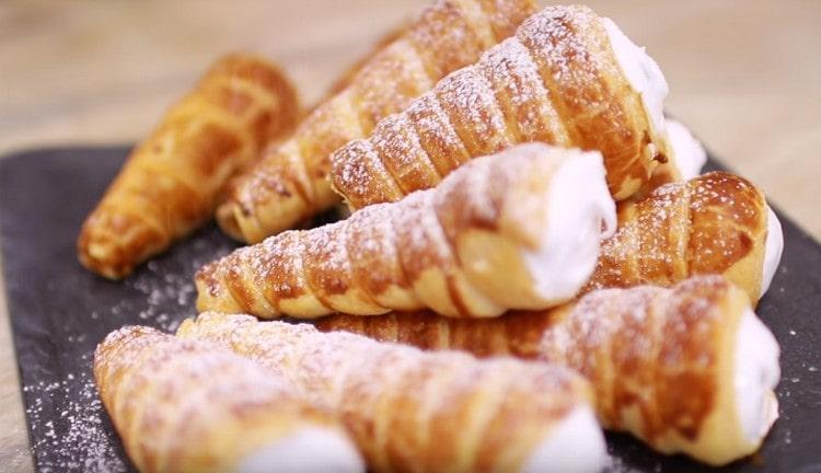 I rotoli di pasta sfoglia con crema proteica possono essere cosparsi di zucchero a velo.