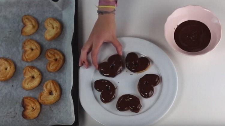 I biscotti orecchie di pasta sfoglia con zucchero possono essere immersi nella glassa, questo migliorerà il suo gusto.