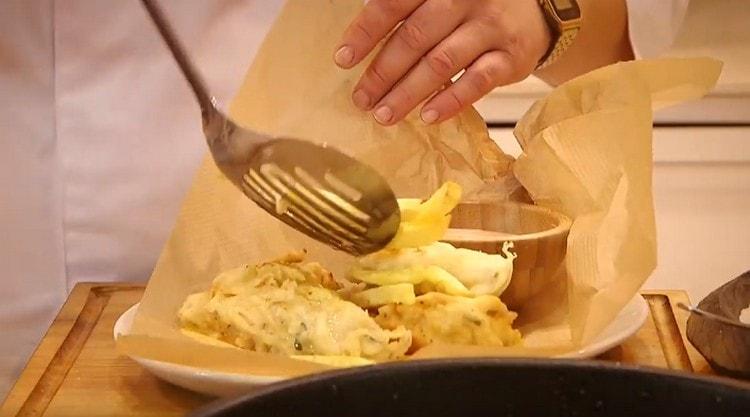 Servire il filetto di merluzzo in pastella con patate fritte e salsa.