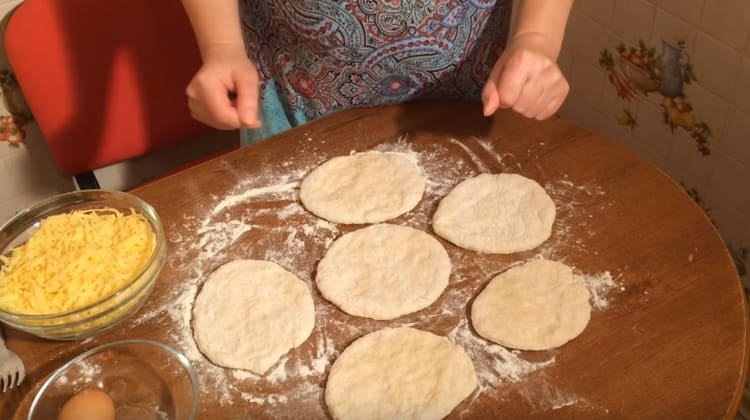 Stendiamo ogni pezzo di pasta o lo impastiamo in una torta piatta con le mani.